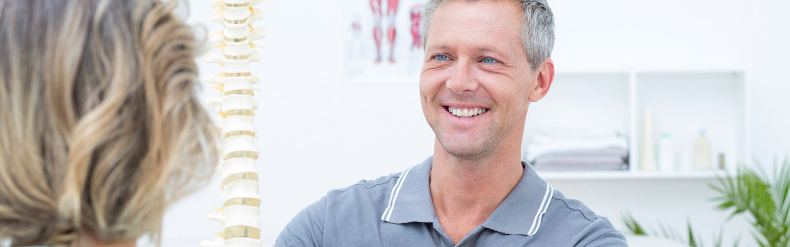 Osteopathic doctor teaching patient about spine