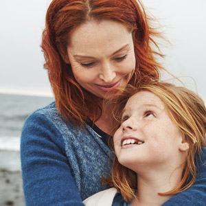 Mom and daughter hugging on the beach