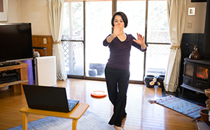 Senior woman doing tai chi at home