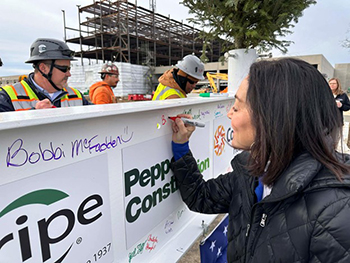 Beth Tharp, SVP Hospital Acute Care Services, signing beam