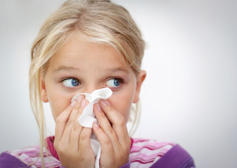 Girl blowing her nose