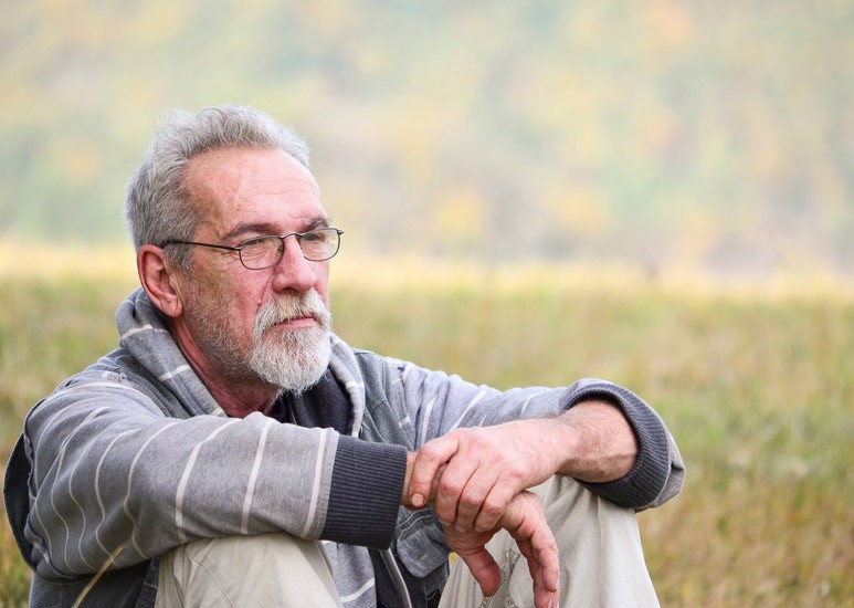 Older man sitting outside
