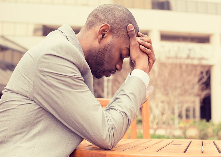 Man with head in hands at table