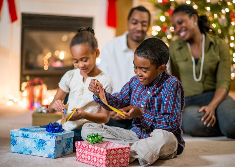 Kids opening Christmas gifts with family
