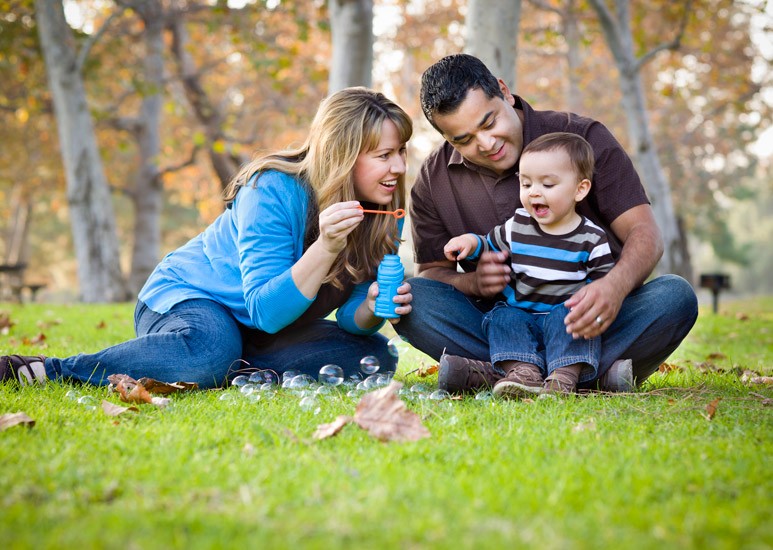 Parents and child blowing bubbles