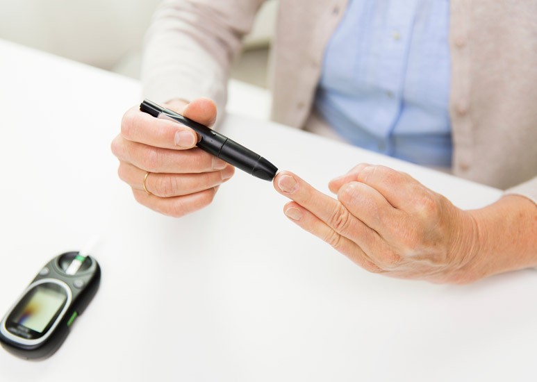 Senior checking diabetes blood sugar