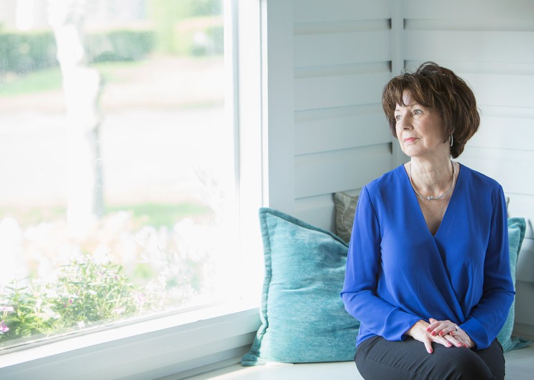 Senior woman with Alzheimer's looking out window