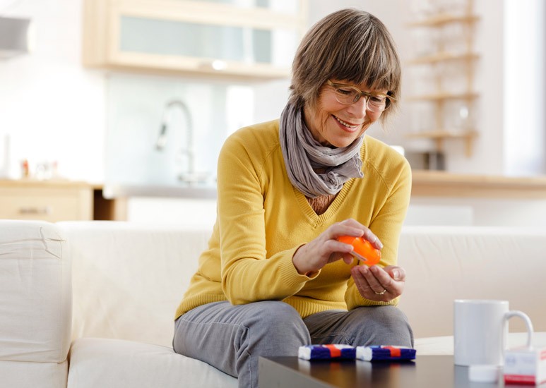 Senior woman taking medication at home