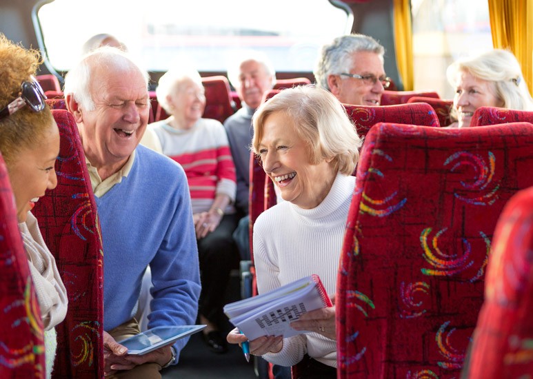 Seniors traveling on bus, doing crossword