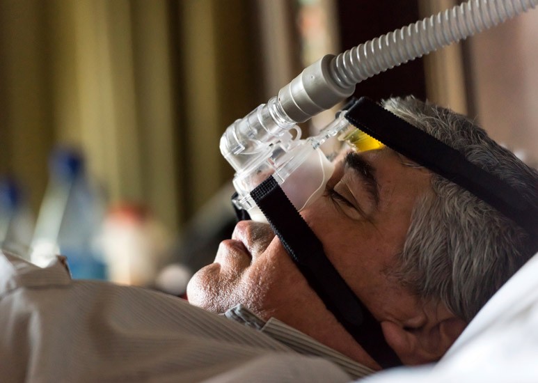 Older man sleeping with sleep apnea mask