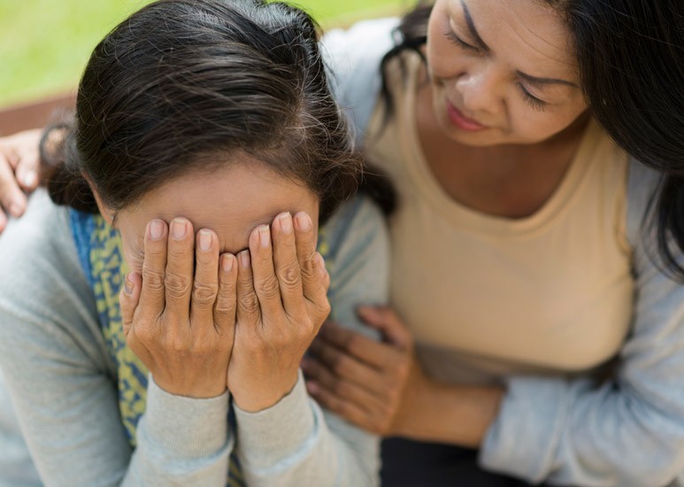 Woman crying, being consoled