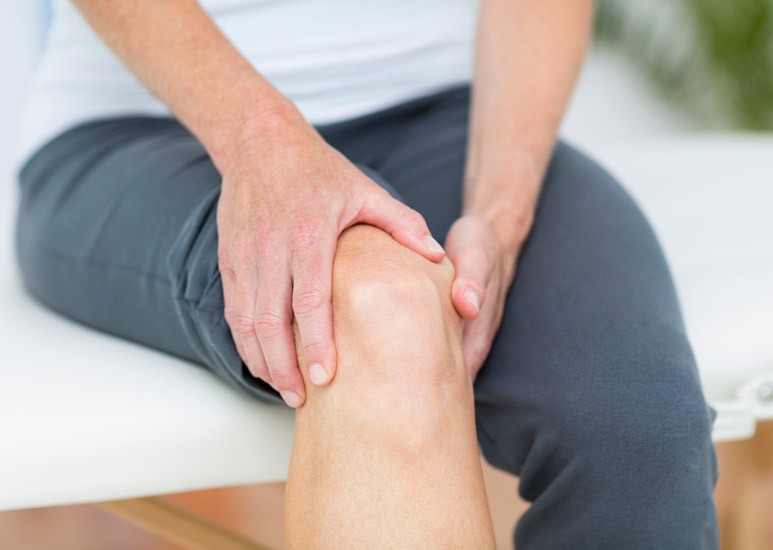 Woman holding painful knee