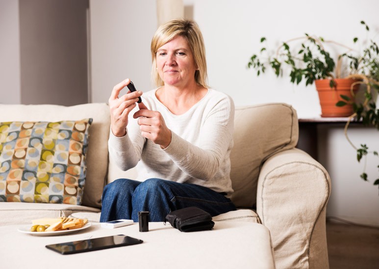 Woman managing her diabetes by testing her glucose
