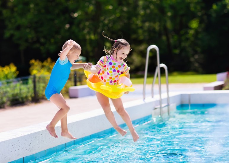 Kids jumping into a swimming pool
