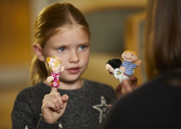 Child and therapist doing play therapy with finger puppets