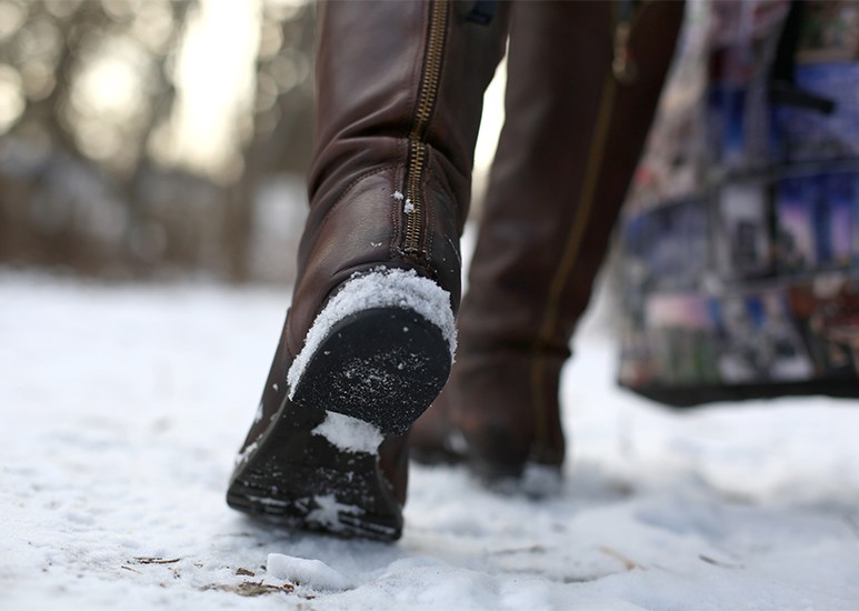 Woman walking on snowy sidewalk