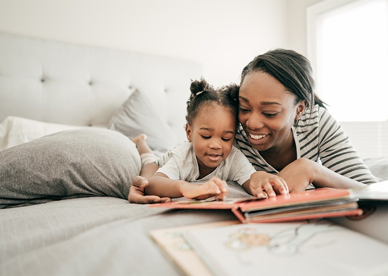Daughter and mom reading in bed