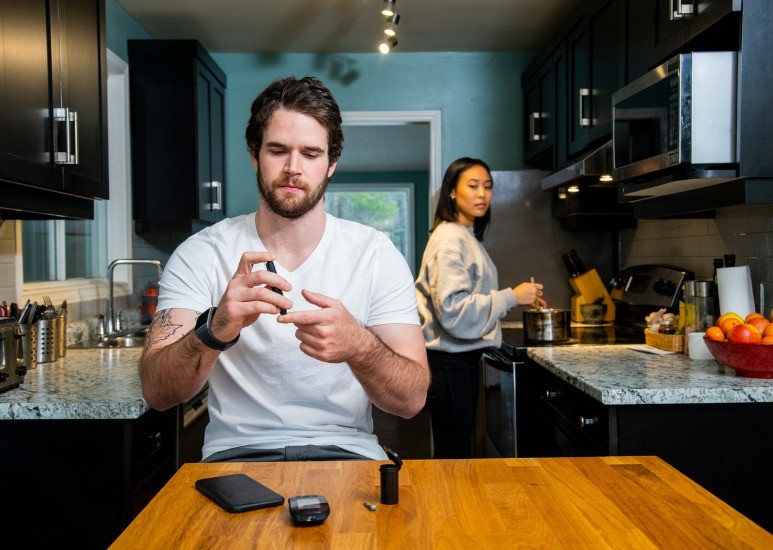 Young man checking his blood sugar level
