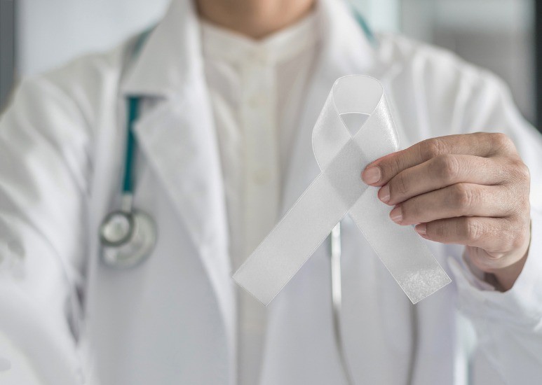 Doctor holding ribbon for lung cancer awareness