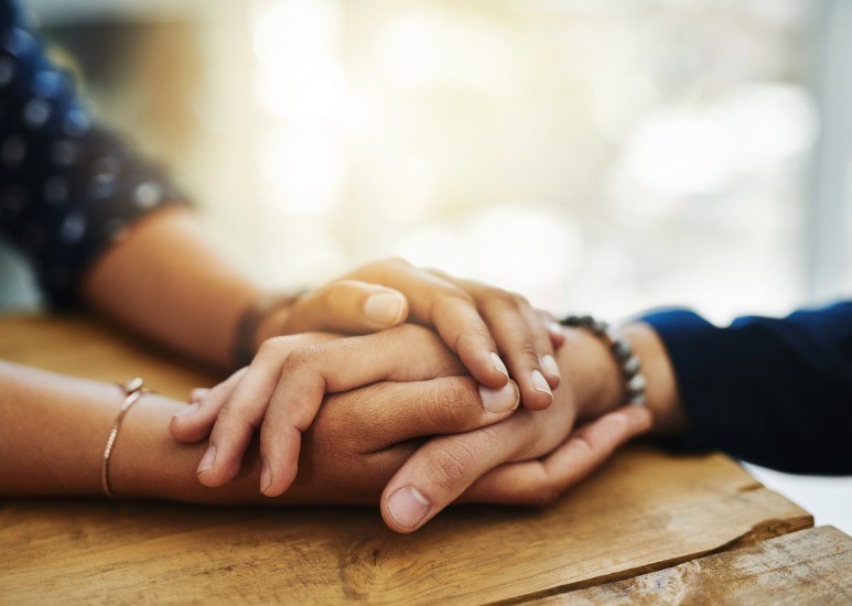 Two people with hands held together