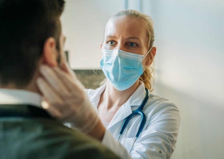 doctor wearing mask giving patient exam