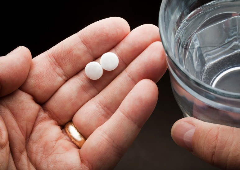 hands holding aspirin
