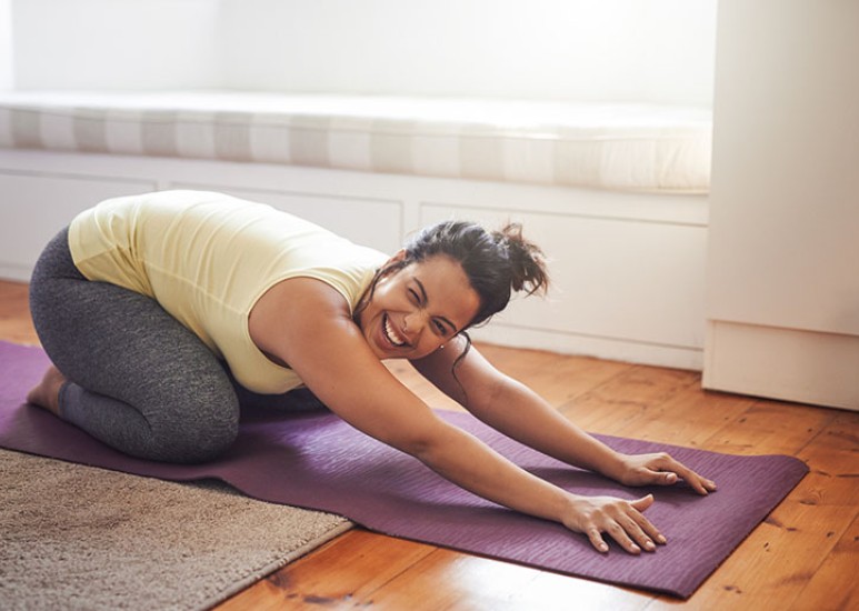 woman stretching lower back at home