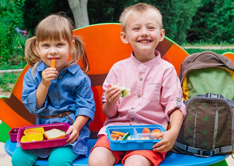 smiling kids with packed lunches