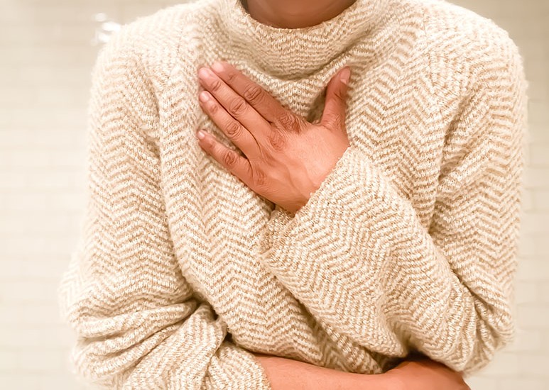 Woman holding hand over lungs