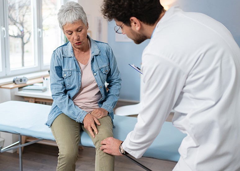 Doctor examining woman's knee