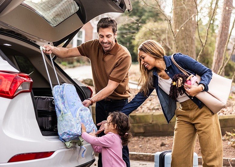 Young family packing the car to go on vacation