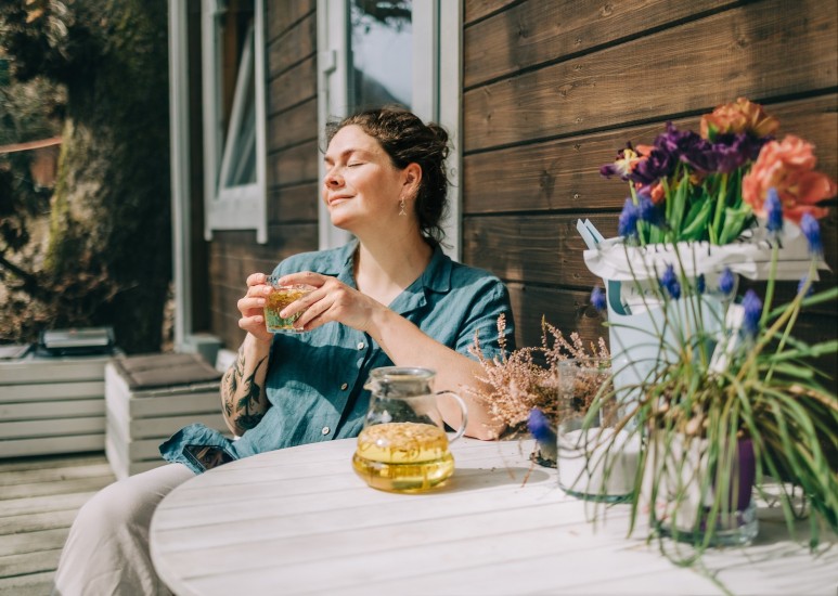 Woman drinking a cup of herbal tea outside on a patio