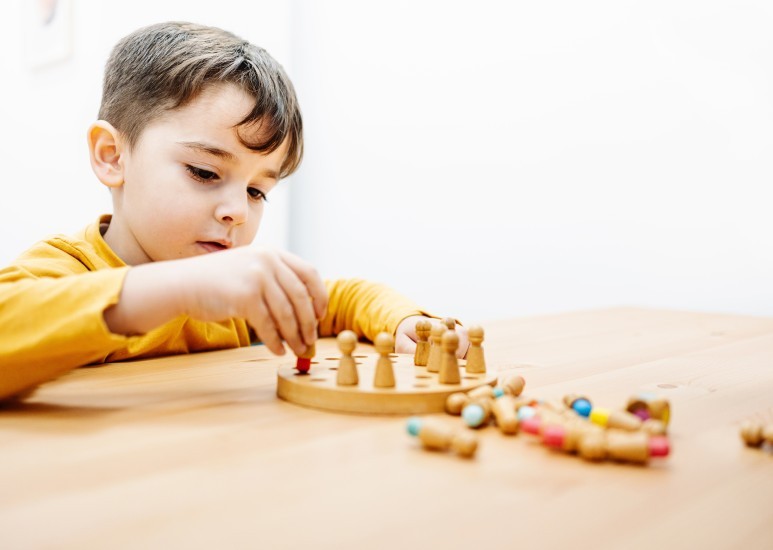 Young child engaged in quiet play with a board game