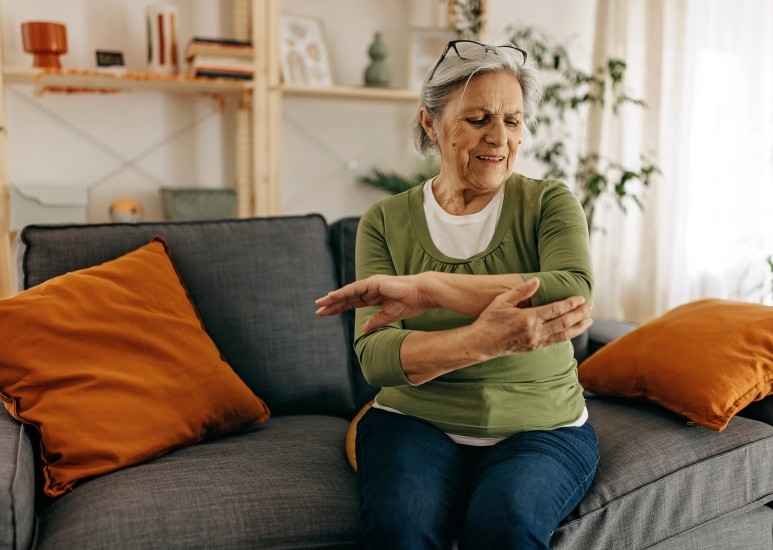 Senior woman rubbing painful elbow