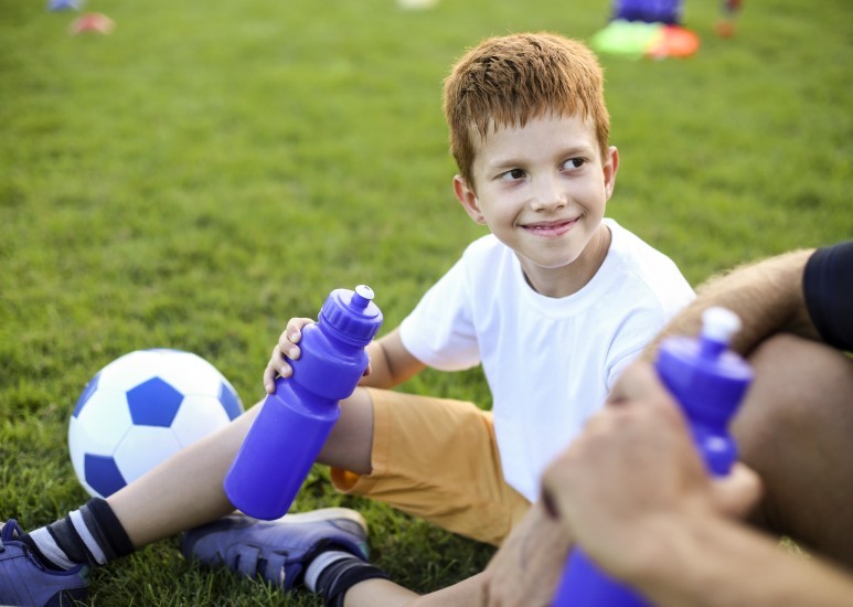 Young athlete taking a water break on the field