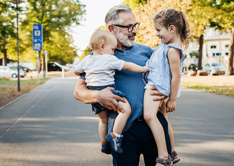 Older man holding his grandkids