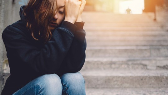 Sad girl sitting on steps