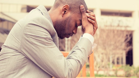 Man with head in hands at table
