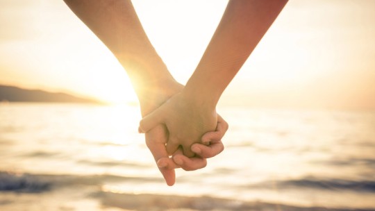 Couple holding hands at sunset