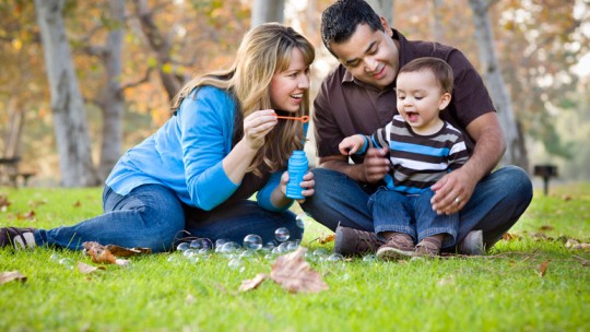 Parents and child blowing bubbles