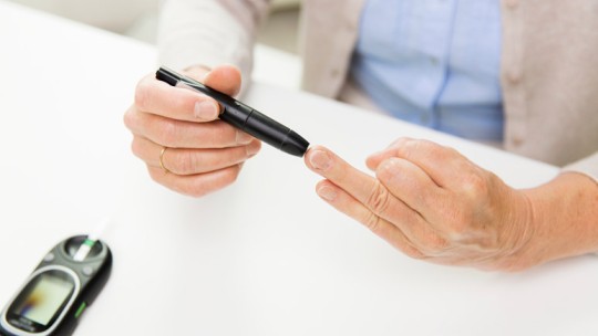 Senior checking diabetes blood sugar