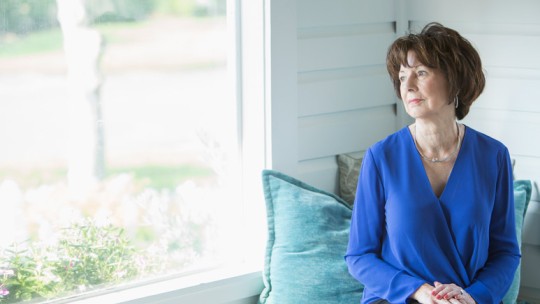 Senior woman with Alzheimer's looking out window