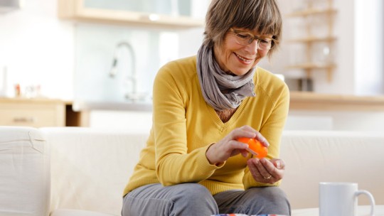 Senior woman taking medication at home