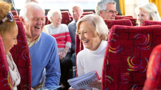 Seniors traveling on bus, doing crossword