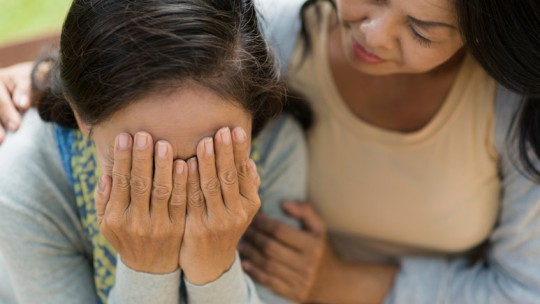 Woman crying, being consoled