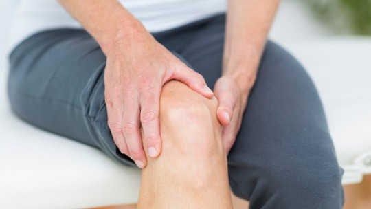 Woman holding painful knee