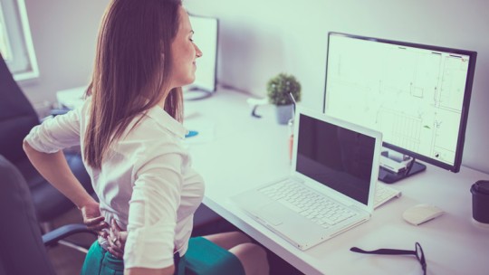Woman with back pain at the office