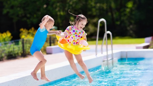 Kids jumping into a swimming pool
