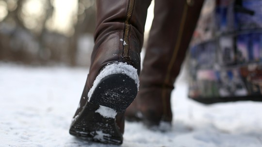Woman walking on snowy sidewalk