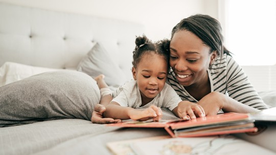 Daughter and mom reading in bed